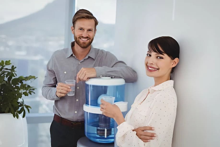 Nhân viên sử dụng máy nước uống với bình 20L